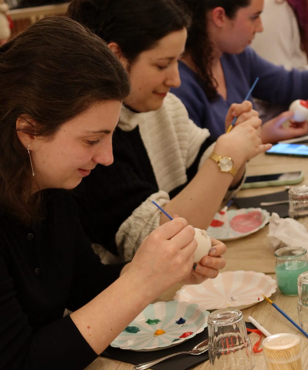Femmes en train de peindre des assiettes ou bols en céramique lors d'un atelier créatif organisé par Toulouse Copines Club
