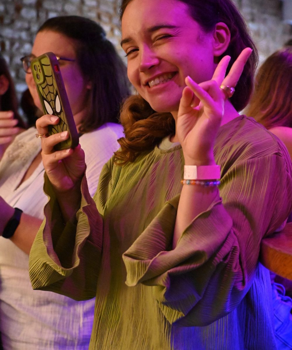 Femme souriante et confiante sur scène lors d'une soirée scène ouverte organisée par Toulouse Copines Club